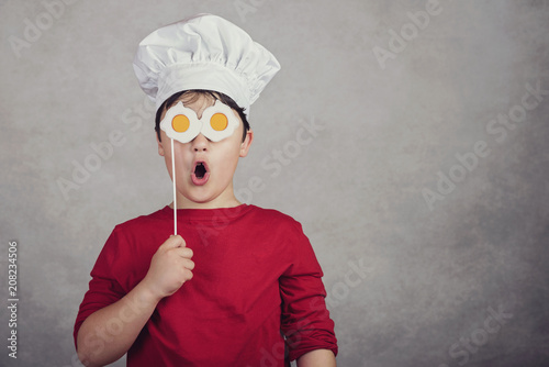 Fotografie, Obraz niño gracioso con huevos fritos en sus ojos