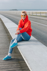 beautiful happy girl in sunglasses sitting and smiling at camera, mont saint michel, france