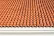 Red corrugated tile element of roof at house and white wall. Shingles roofing surface tiles overlay pattern and texture