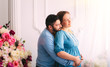 © Kolomiiets Viktoriia - Husband touching the belly of the pregnant wife.Family and pregnancy concept.Tender moment.Flower background,next to the window