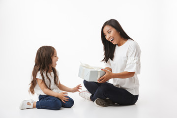 Poster - Cute young asian woman mother gives a present gift box to her little girl child daughter