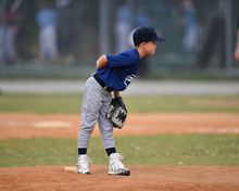 Young Boy Pitching The Ball In A Baseball Game