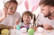 © Pixel-Shot - Painted Easter eggs and blurred family on background