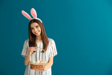 Beautiful Young Woman With Easter Eggs And Bunny Ears On Color Background