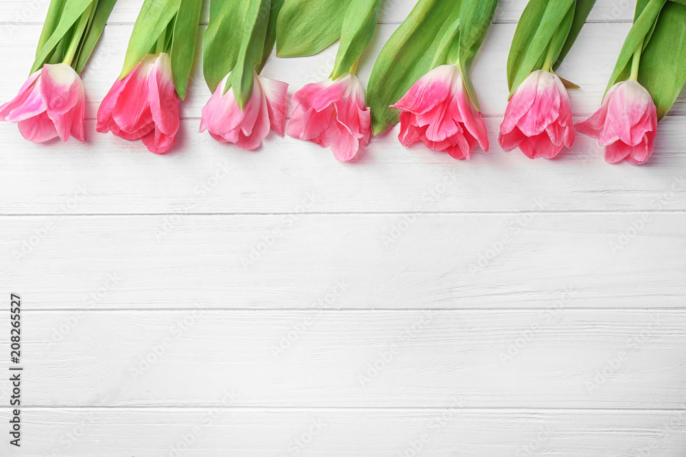 Beautiful tulips on white wooden background
