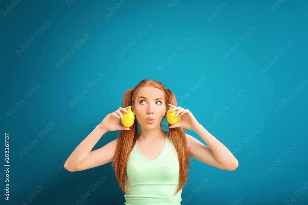 Emotional young woman with citrus fruit on color background