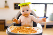 © Louis-Photo - Little baby girl eating her spaghetti dinner and making a mess
