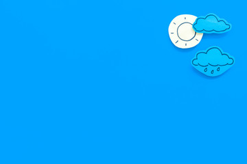 Wall Mural - clear and cloudly weather icons on blue background top view copy space