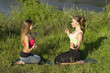 Two Young beautiful women doing peacefully yoga outdoors