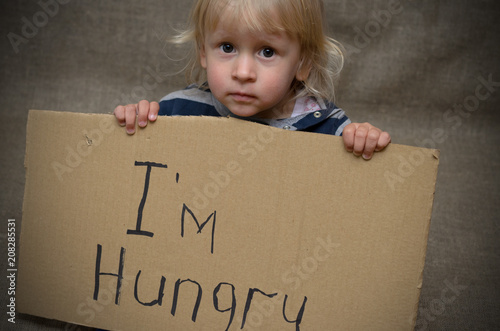 Cuadros en Lienzo A hungry boy and a girl with a cardboard tablet with the inscription I'm hungry