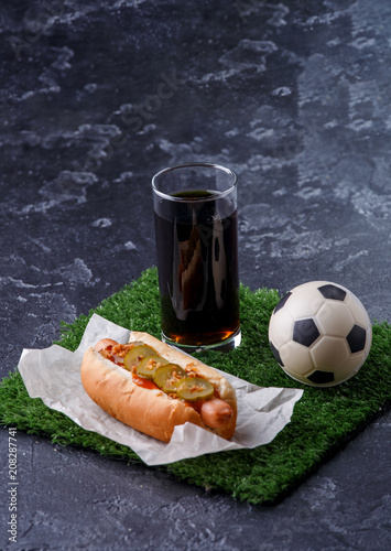 Photo of glass of beer, green grass with soccer ball, hotdog Poster