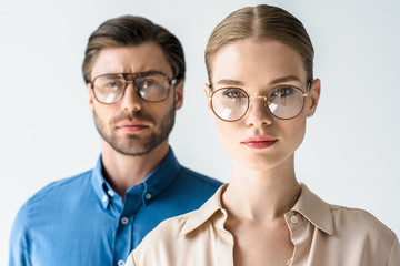 close-up portrait of attractive young man and woman in stylish clothing and eyeglasses isolated on white