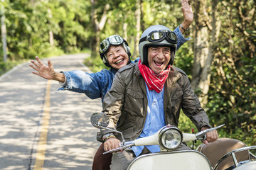 Senior couple riding a classic scooter