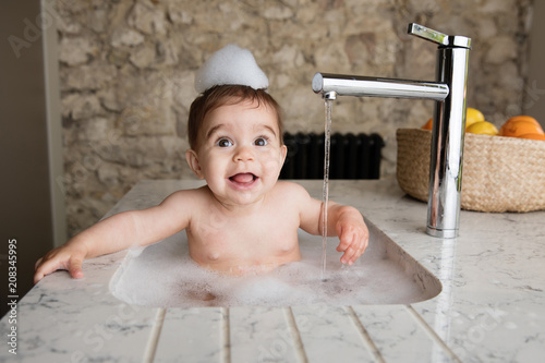 Smiling Baby Taking Bubble Bath In Kitchen Sink Buy This