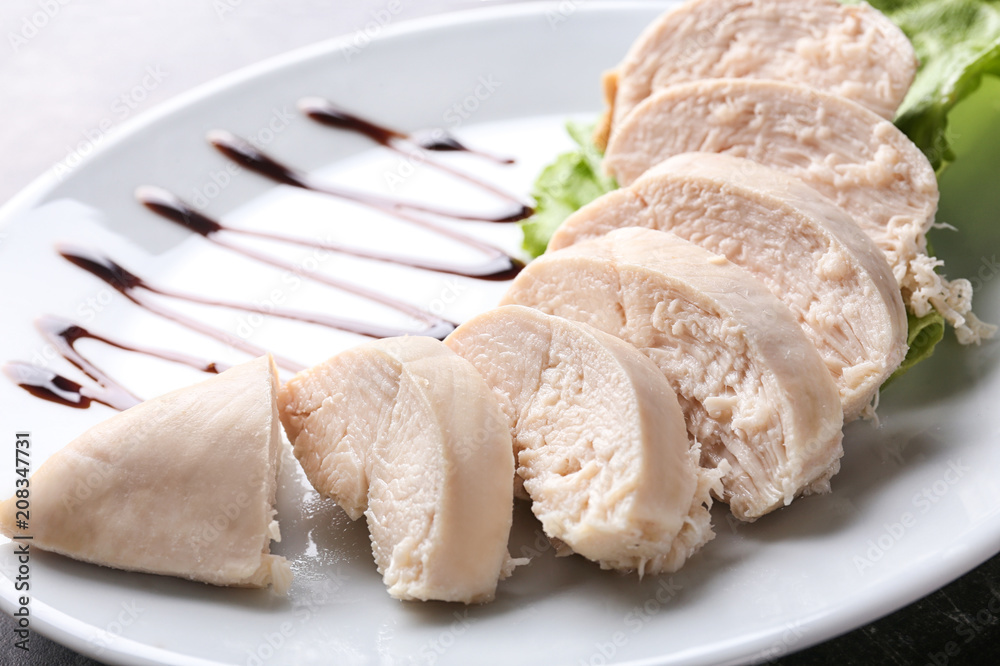 Sliced boiled chicken fillet on plate, closeup