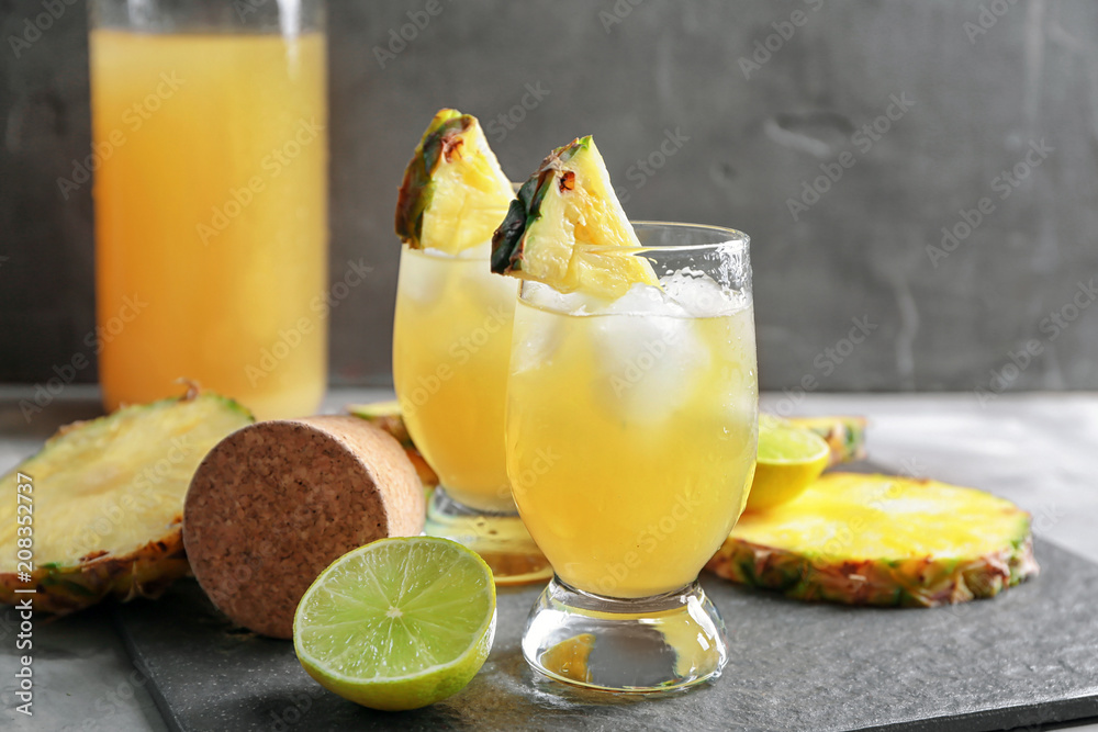 Glasses of tasty fresh pineapple juice on table