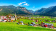 Alpine green fields and traditional wooden houses view of the Gosau village at autumn sunny day.