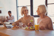© Viacheslav Yakobchuk - Friendly chat. Two charming elderly women sitting at the counter in the cafe and chatting while one of the women eating salad and the other one drinking coffee