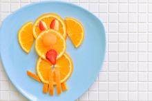 A Children's Breakfast From An Orange In The Form Of A Dog. Dessert For Baby, Animal On Plate