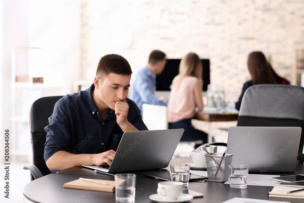 Young man using laptop to get ready for business meeting in office