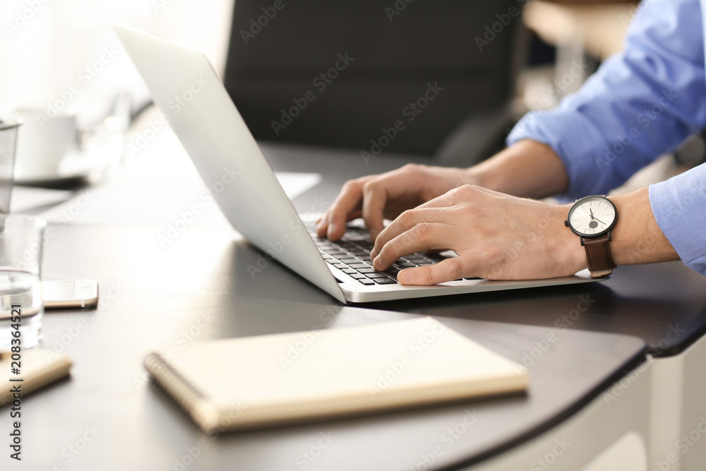 Young man using laptop to get ready for business meeting in office