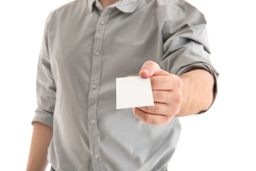 Young man with business card on white background