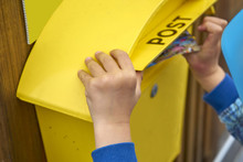 Childs Hand Puts Blank Postcard In An Italian Yellow Post Box Pi