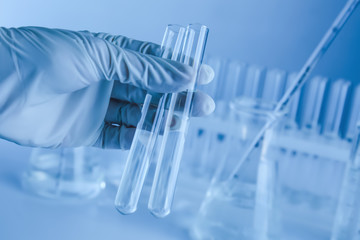 Scientist holding test tubes with liquid in laboratory