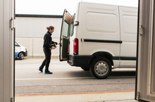 Side View Of Manual Worker Closing Delivery Van While Standing On Road