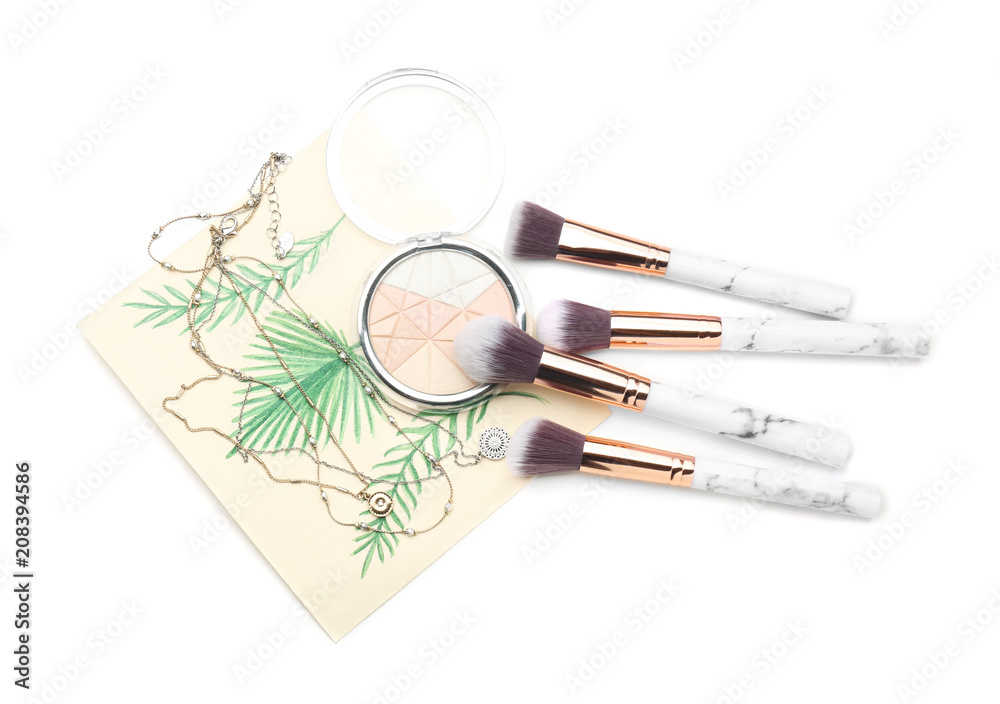 Composition with decorative cosmetic, brushes and necklaces on white background