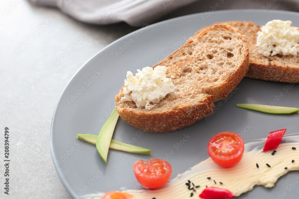 Toasted bread served with cream cheese and butter on plate, closeup
