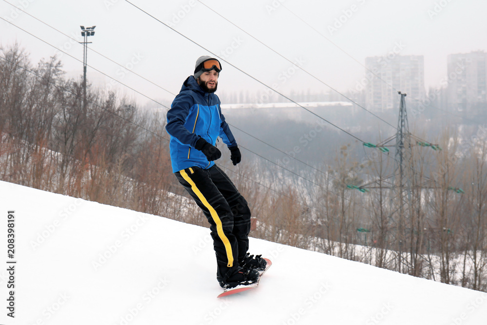 Male snowboarder on slope at winter resort