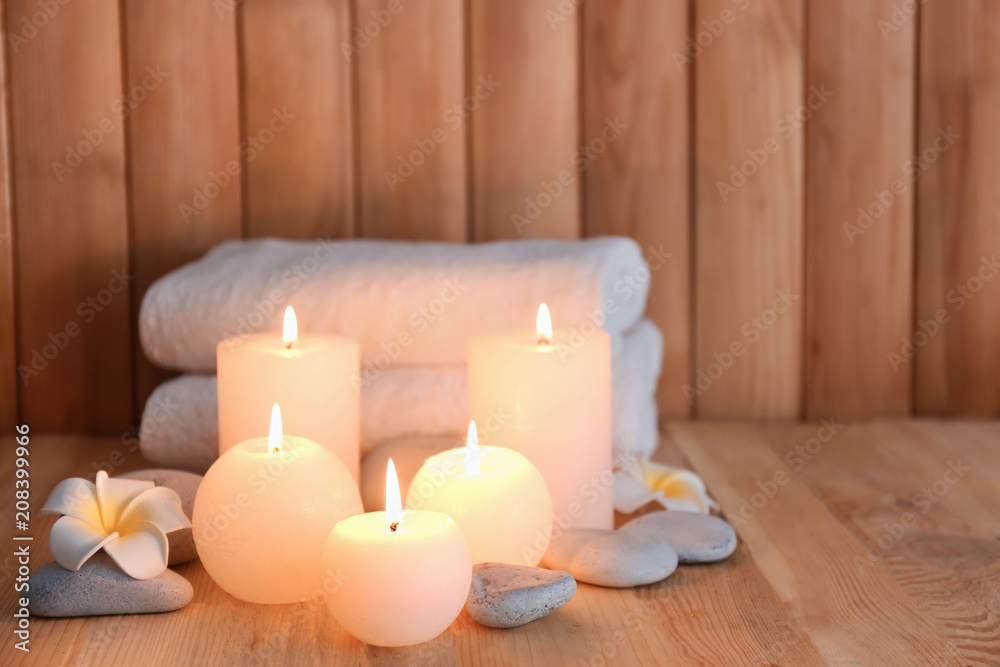 Beautiful spa set with burning candles on wooden background