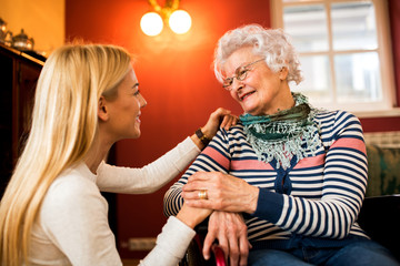 Wall Mural - Young woman comfort her grandmother in wheelchair about her health condition