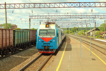 Arrival of the passenger electric locomotive to the railway station. One-section electric locomotive. Background.