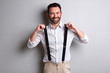 trendy man with beard holding suspenders