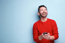 Cheerful Man With Mobile Phone Looking Up