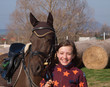 Young smilling girl with her pony before showjumping competition