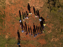 Aerial View Of Children Playing With Teachers Of "ring Around The Rosy" In The Backyard Of The School.