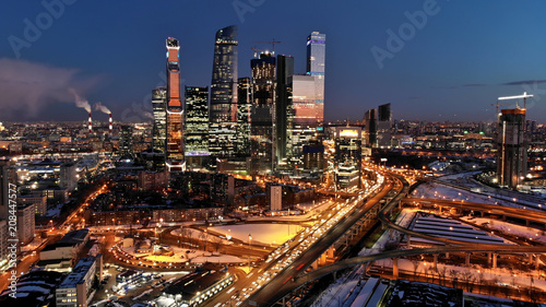 Plakat Moskwa-miasto nocne życie dolly strzał. Ruch uliczny i nocne oświetlenie. Drapacze chmur z oświetlone okna w środku skrzyżowania ruchu.