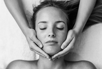 Wall Mural - Young woman receiving a head massage in a spa center.