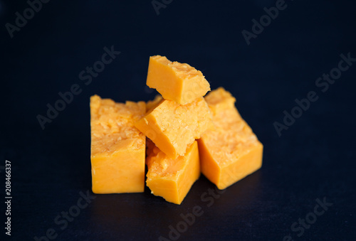 Fotografia Cheese in peaces on the black background horizontal