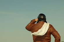 Portrait Of A Vintage Pilot With Leather Cap, Scarf And Aviator Glasses Looks Into The Distance - Portrait Of A Man In Historical Pilot Clothing