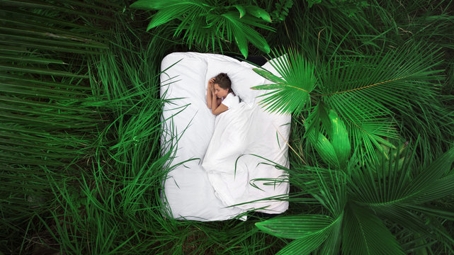 Fototapete - A hidden place. Sleeping woman in deep jungle forest lies on airbed,View from above