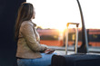 © terovesalainen - Lady sitting and waiting for train in station. Woman in platform at sunset with suitcase, ticket and passport.