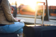 © terovesalainen - Woman waiting for train with passport, ticket and suitcase. Lady with baggage in station at sunset. Travel, vacation and transportation concept.