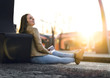 © terovesalainen - Laughing and happy woman waiting train at station. Sitting on the ground with passport and ticket. Going on a vacation and traveling.
