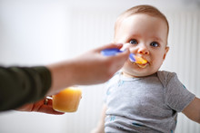Mother Feeds Baby With Fruit Porridge