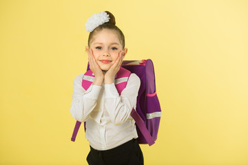 Wall Mural - beautiful little girl with bow on head and with briefcase on yellow background