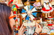 Woman customer looking at wooden toys at the souvenir market